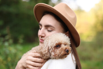 Portrait of woman with cute dog outdoors