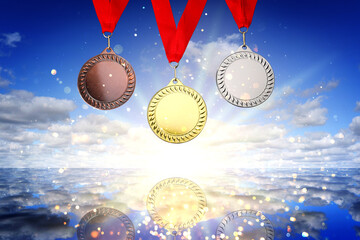 Gold, silver and bronze medals against sky over sea
