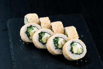 Japanese lunch set of sushi rolls with cucumber, zucchini, cream cheese, rice, nori and sesame seeds.