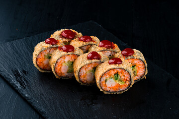 Set of tempura sushi rolls with shrimp, avocado, cucumber, tobiko caviar and red sauce.