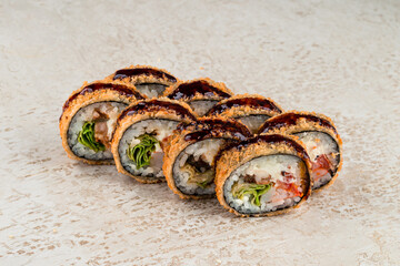 Set of fried sushi rolls with shrimp, sea bass, lettuce, cream cheese, sweet pepper and teriyaki sauce.