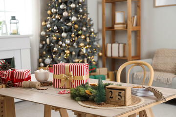 Calendar with date of Christmas, presents and cocoa on table in living room
