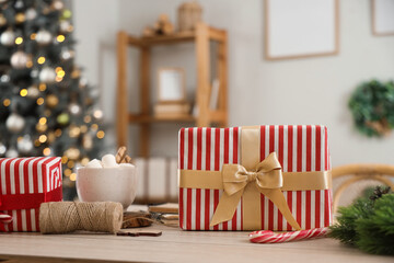 Christmas presents with cup of cocoa on table in living room, closeup