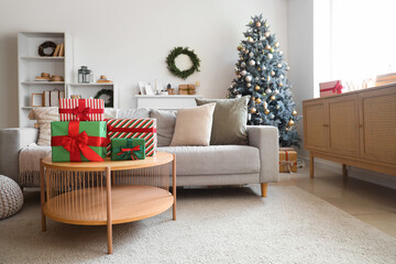 Obraz premium Interior of light living room with sofa, Christmas tree and presents on table