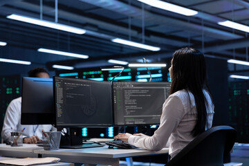 Software developers in data center running system diagnostic tests on PC to fix problems. IT staff...