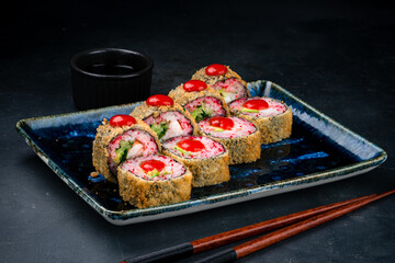 Set of fried sushi rolls with shrimp, cream cheese, avocado, flying fish caviar and sauce.