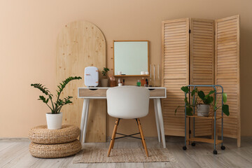 Interior of makeup room with mirror, table and folding screen
