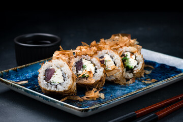 Set of Japanese sushi rolls with tuna, cream cheese, cucumber in dry shavings of tuna.