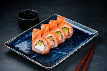 Sushi rolls Philadelphia with salmon, cream cheese, avocado, rice and nori.