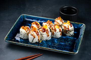 Japanese sushi rolls with tuna, cream cheese, avocado, mango and teriyaki sauce.