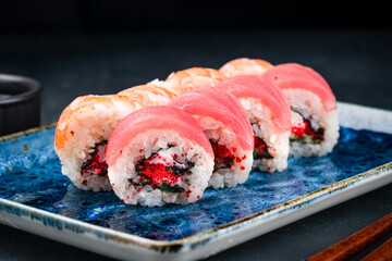 Set of sushi rolls with tuna, shrimps, cream cheese, avocado, flying fish caviar and marinated chuka seaweed.