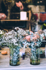 Chic bouquets of seasonal flowers in glass vases