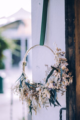 Handcrafted wreath with dried flowers and eucalyptus hanging on a door frame