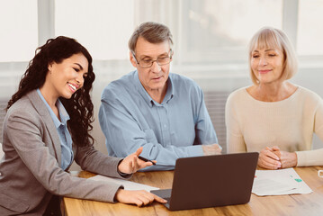 Real Deal. Older couple considering new home purchase talking with estate agent who showing them...