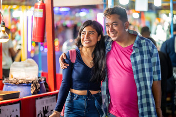 The bride and groom walk through the streets of their city and look for where to eat delicious dishes.