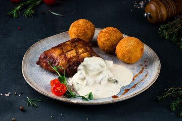 chicken fricassee with fried potatoes, on a black background