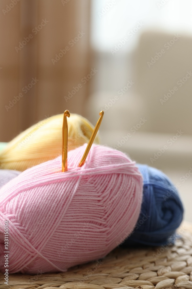 Sticker Knitting material. Skeins of soft yarn and crochet hooks on wicker surface indoors, closeup