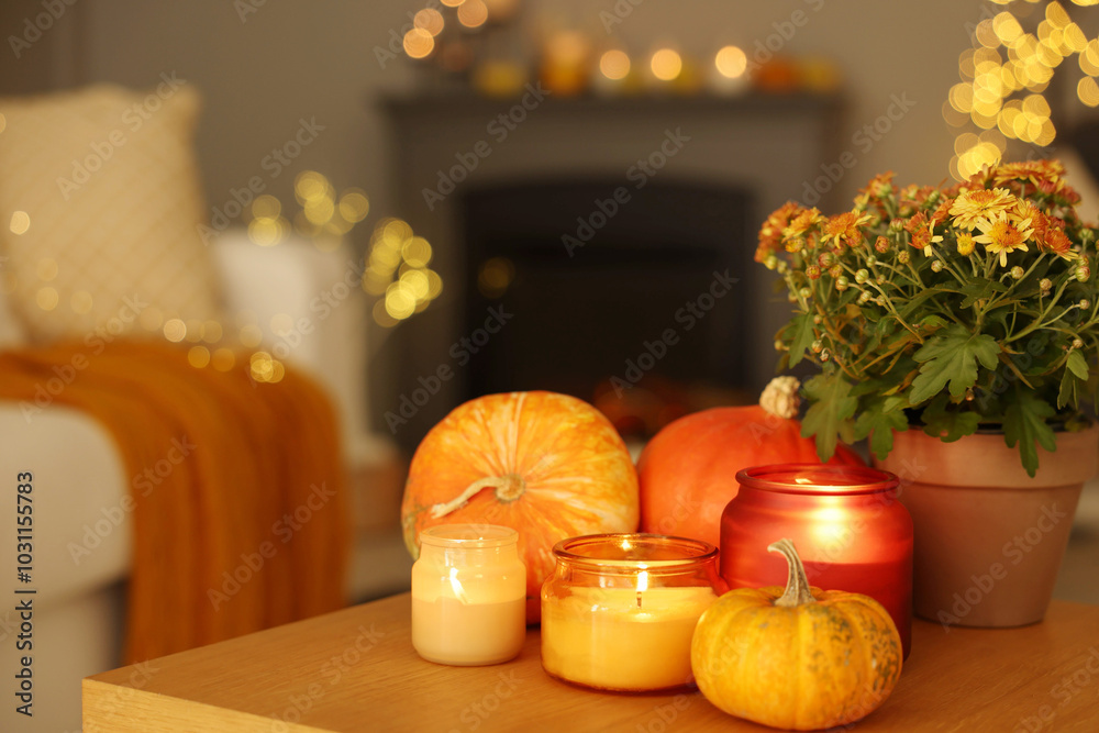 Poster Burning candles, pumpkins and flowers on wooden table indoors, space for text. Autumn atmosphere