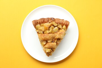Slice of homemade apple pie on orange background, top view
