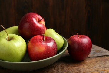 Fresh red and green apples on wooden table, closeup