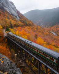 North Conway, New Hampshire - October 14, 2021: Passing Train Conway on Tracks Fall Foliage Scenic New England. Mount Washington Valley Forest