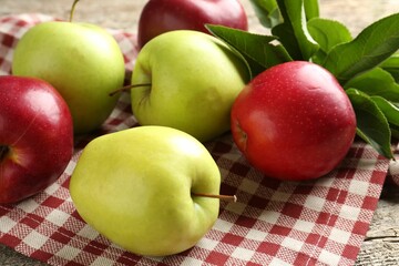 Ripe apples and green leaves on table, closeup