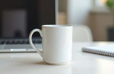A plain white coffee mug sits beside a laptop and notepad on a wooden desk in a cozy workspace during daylight hours