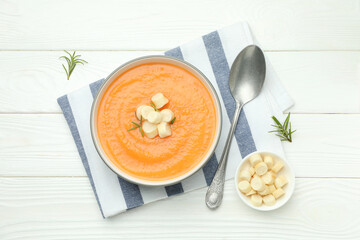 Delicious sweet potato soup with croutons on white wooden table, flat lay