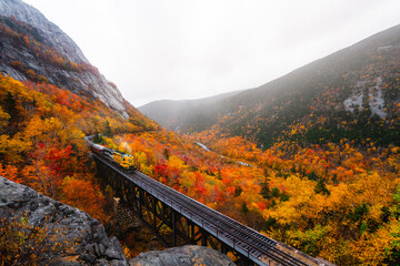 North Conway, New Hampshire - October 14, 2021: Upcoming Train With Steam Smoke Conway on Tracks Fall Foliage Scenic New England. Mount Washington