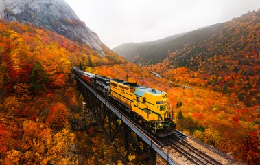 North Conway, New Hampshire - October 14, 2021: Famous Conway Train Touring New England Scenic Ride on Tracks Fall Foliage. Colorful Forest Trees