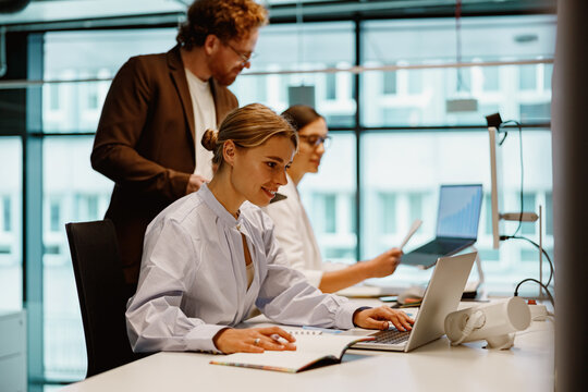 Professionals collaborating in a modern office, leveraging technology and teamwork to reach their goals
