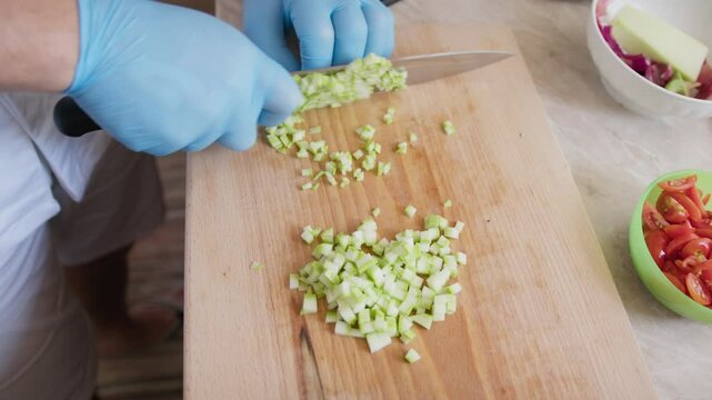 Chef Cuts Zucchini Vegetable Brunoise Style In Restaurant Kitchen