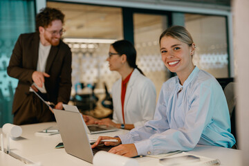A diverse group of young professionals is actively collaborating in a vibrant, modern office...