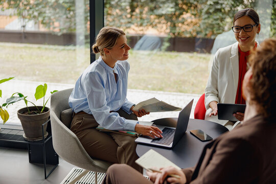 A collaborative team meeting is taking place with a variety of skilled professionals in a bright office environment