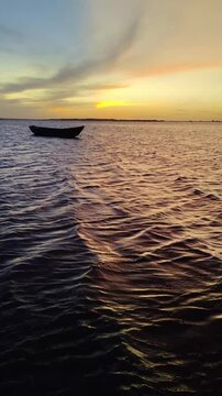 Beautiful shot of a fishing boat silhouette in the ocean at sunset | 4K Vertical shot | Atins, Len&ccedil;&oacute;is Maranhenses, Maranhao, Brazil