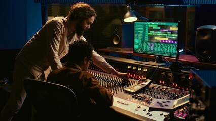 Diverse team of musician and audio technician creating a hit song, working in professional music...