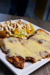 Grilled and Gratinated Chicken Breast: A deliciously tender chicken breast, perfectly grilled and topped with a golden gratin. Accompanied by a fresh salad featuring crisp lettuce, juicy pineapple, an