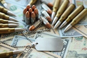 The medallion of a military soldier and cartridges lies on dollar bills