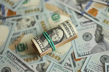Money close up. A roll of one American dollars on 100 USD banknotes