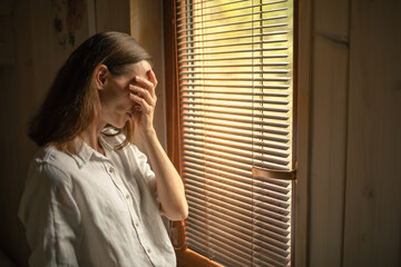 sad unhappy woman in her bedroom suffering from depression, stress, mental health issues	