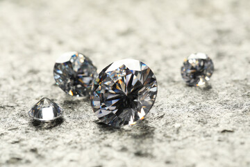Many beautiful shiny diamonds on grey table, closeup