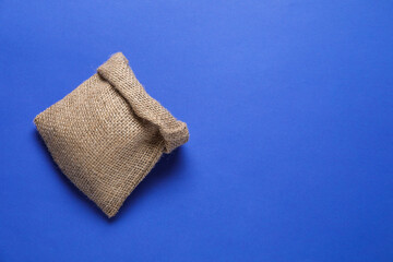 One burlap sack on blue background, top view. Space for text