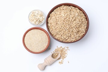 Oat grains, flakes and bran in bowls isolated on white, top view