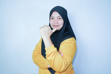 hijab woman giving thumbs up. wearing yellow clothes. isolated white background