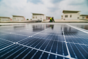 Fototapeta premium A close up of solar panels with a worker blurred in the background. The focus on the panels emphasizes the importance of renewable energy technology and solar power installations.