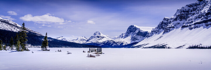 Stunning panorama view of  Frozen Bow Lake and the surrounding mountains in the Canadian Rockies. This panorama was taken early May 2024 and the lake was still frozen.