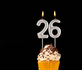 Birthday cupcake on black background - Number 26 shaped candles.