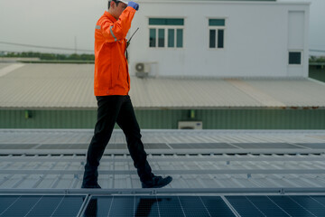 Naklejka premium engineer man inspects construction of solar cell panel or photovoltaic cell by electronic device. Industrial Renewable energy of green power. factory worker working on tower roof.