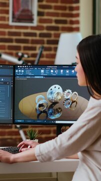 Vertical Video Professional industrial designer working with CAD software on dual monitors, creating 3D prototypes for a tech driven environment. 3D modeling software for innovative design. Camera B.