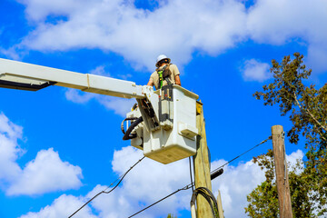 Professional electrician is working on repairing electric power system after Hurricane by using...